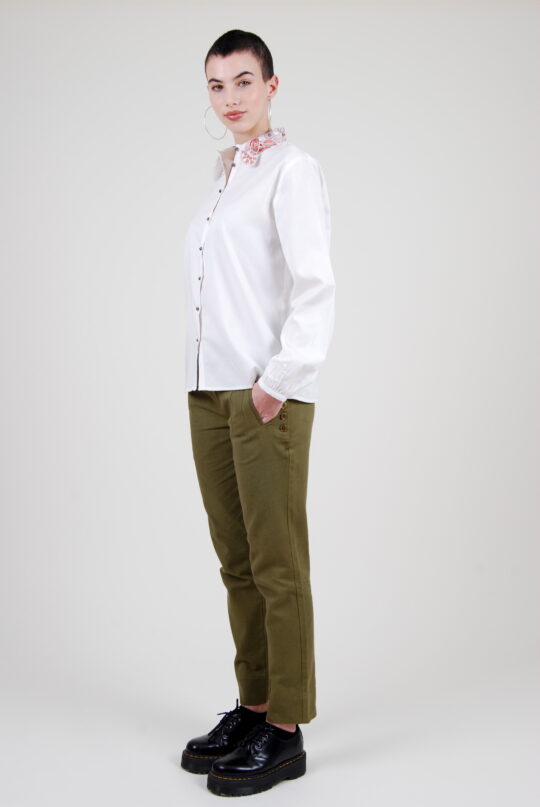Le mannequin porte la chemise vegan Ami conçue avec du coton biologique et sa broderie fleurs et paons
